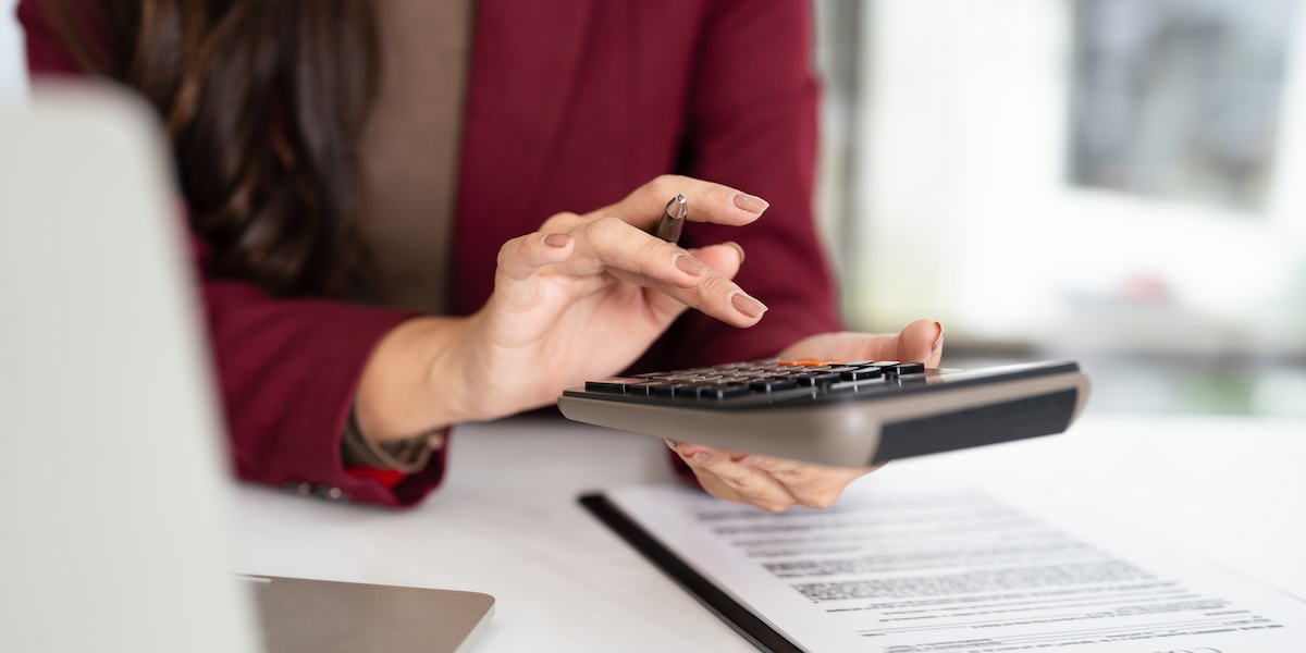 Finance, budgeting and tax calculation. Close up woman hand using calculator to calculate finance, accounting.