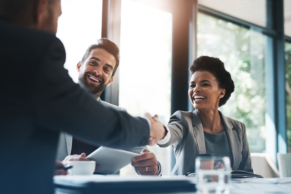 Happy business people, handshake and meeting in teamwork for partnership or collaboration in boardroom.